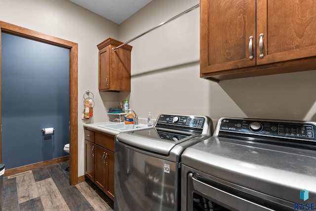 laundry room featuring baseboards, washer and dryer, a sink, dark wood finished floors, and cabinet space