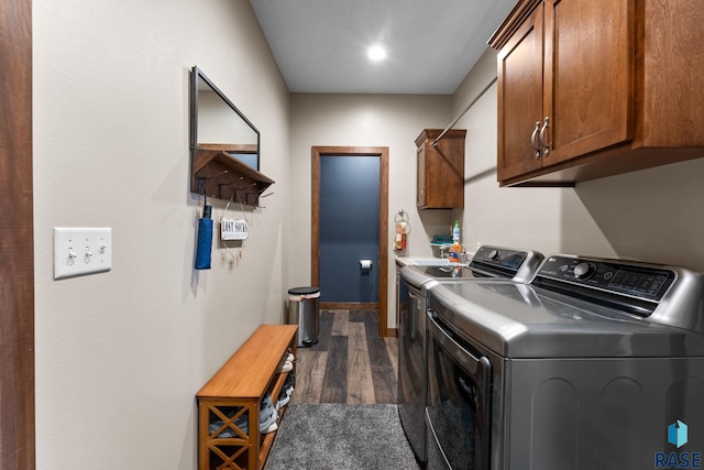 laundry room with dark wood finished floors, independent washer and dryer, and cabinet space