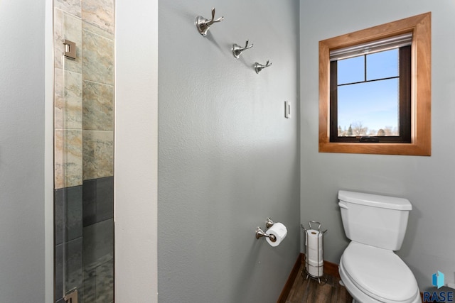 bathroom with toilet and baseboards