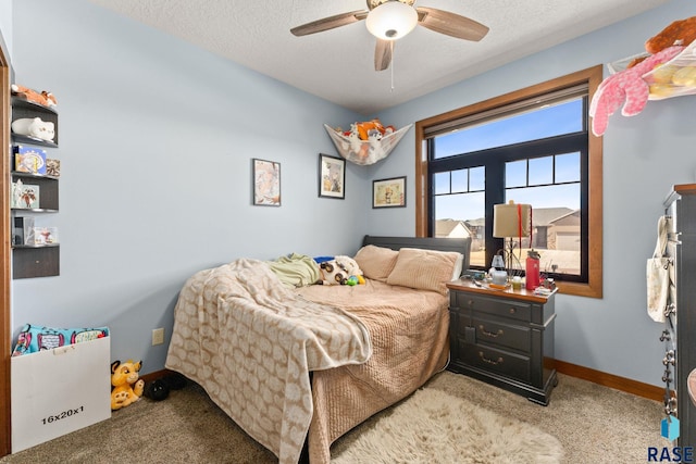 carpeted bedroom with baseboards, a ceiling fan, and a textured ceiling