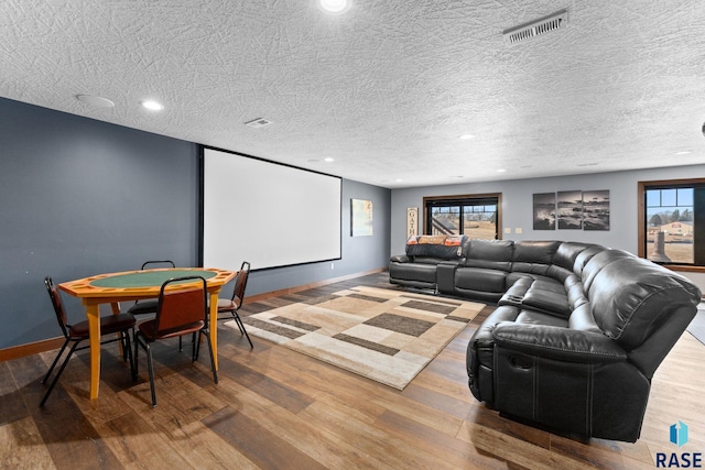 home theater room featuring recessed lighting, visible vents, baseboards, and wood finished floors