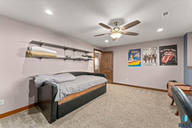 bedroom with carpet flooring, visible vents, baseboards, and a textured ceiling