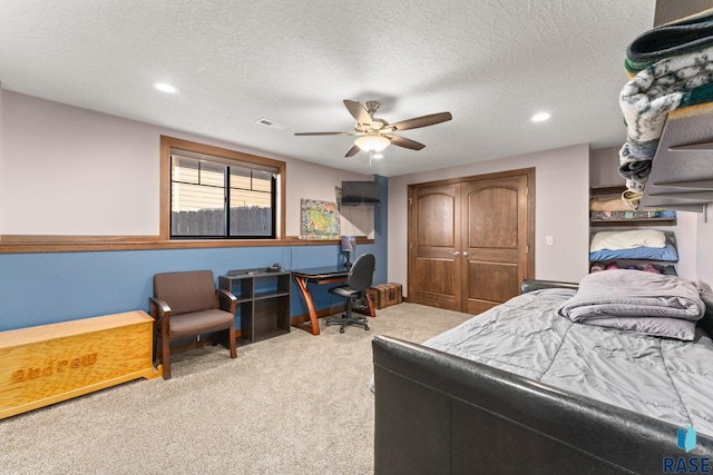 bedroom featuring a textured ceiling, a closet, a ceiling fan, visible vents, and carpet floors