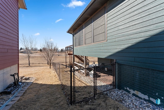 view of property exterior featuring fence, a gate, and stairway