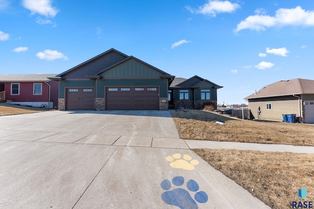 view of front of property featuring a garage, driveway, board and batten siding, and stone siding