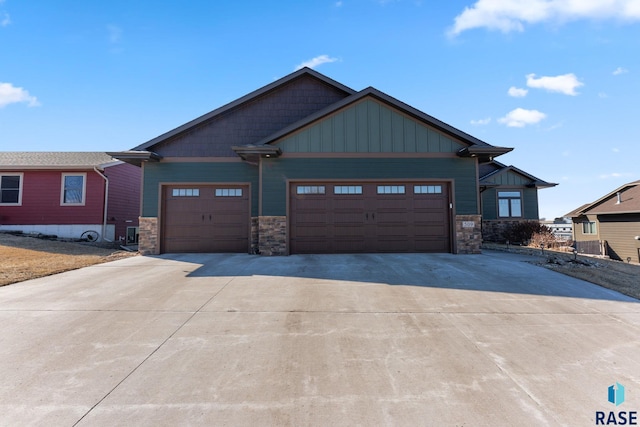 craftsman inspired home with an attached garage, board and batten siding, concrete driveway, and stone siding