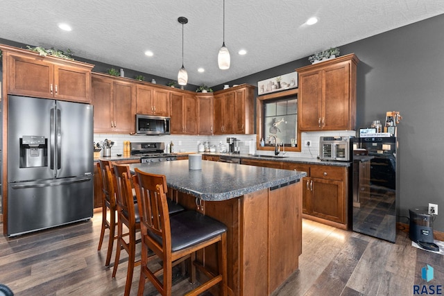 kitchen with stainless steel appliances, dark wood-style floors, beverage cooler, and a sink