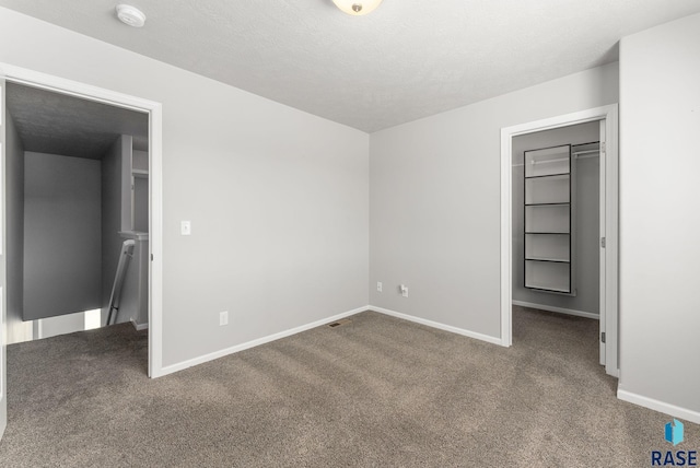 unfurnished bedroom featuring carpet, visible vents, and baseboards