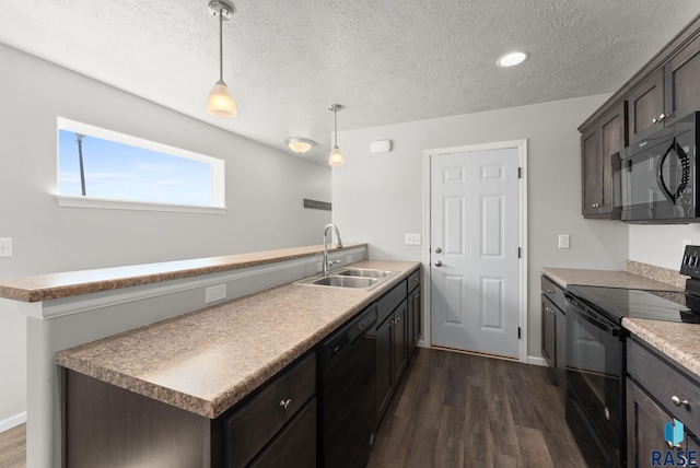 kitchen featuring hanging light fixtures, a sink, a peninsula, dark wood finished floors, and black appliances