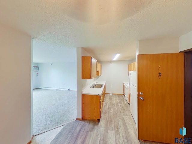 320 N Western Ave, Sioux Falls, SD 57104 - kitchen with light wood-style flooring, a textured ceiling, light countertops, a sink, and baseboards