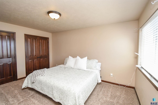 carpeted bedroom with baseboards and a textured ceiling