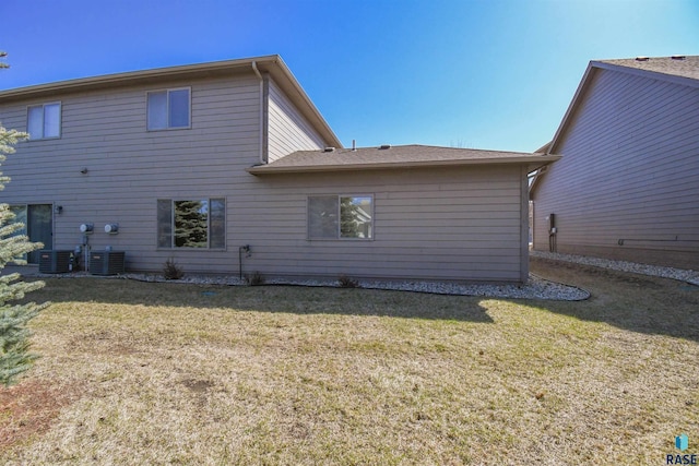 back of house with a yard and central air condition unit