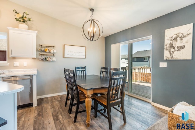 dining space featuring an inviting chandelier, baseboards, and dark wood-style flooring
