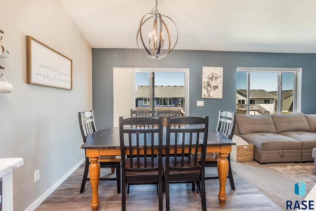 dining area featuring baseboards, an inviting chandelier, and wood finished floors