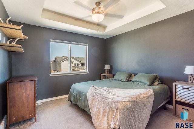 bedroom with a raised ceiling, a baseboard radiator, carpet flooring, and baseboards