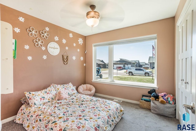 carpeted bedroom with a closet, baseboards, and ceiling fan