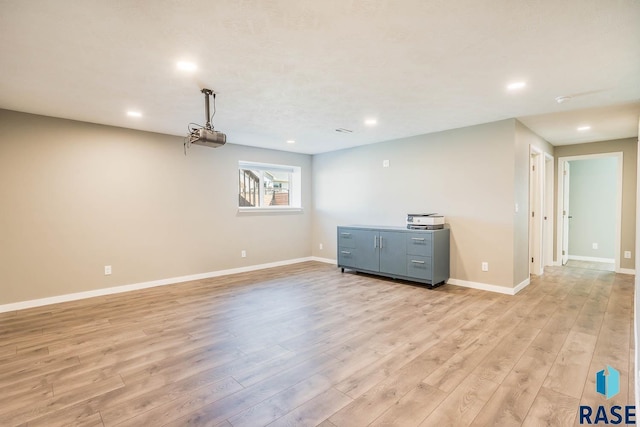 empty room featuring light wood-style floors, baseboards, and recessed lighting