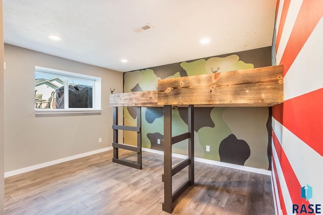 bedroom with recessed lighting, visible vents, baseboards, and wood finished floors