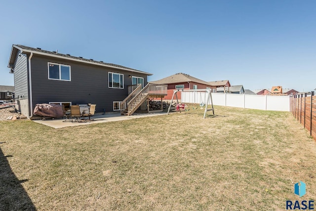 back of property with a patio area, a fenced backyard, a deck, and a yard