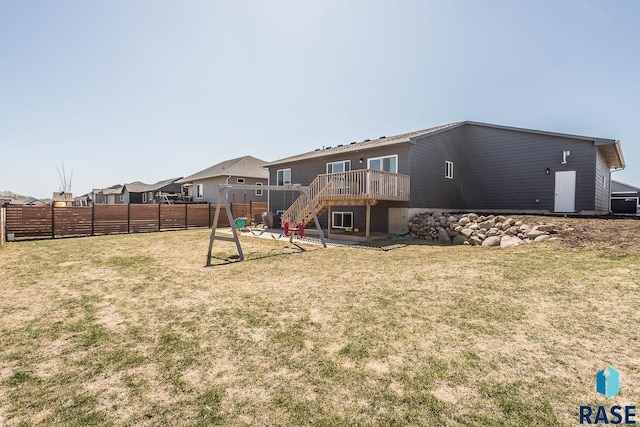 rear view of property with a fenced backyard, a deck, stairway, and a lawn