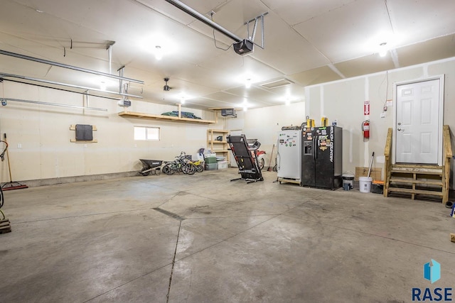 garage featuring a garage door opener and freestanding refrigerator