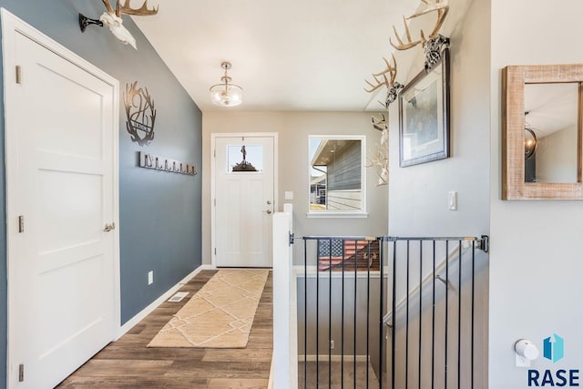 foyer entrance with wood finished floors and baseboards