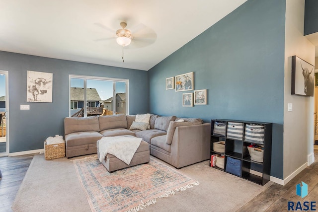 living room with baseboards, vaulted ceiling, a ceiling fan, and wood finished floors