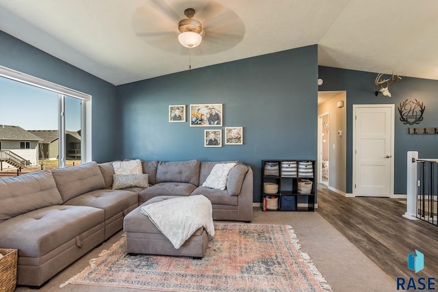 living room featuring wood finished floors, baseboards, a ceiling fan, and vaulted ceiling