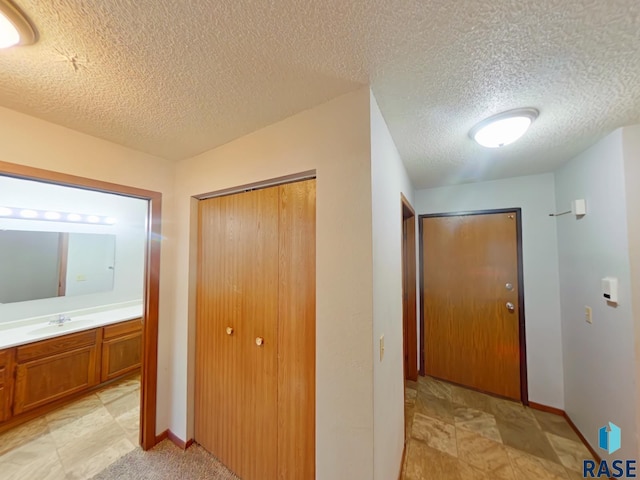901-909 N Cleveland Ave, Sioux Falls, SD 57103 - hallway featuring a sink, baseboards, and a textured ceiling