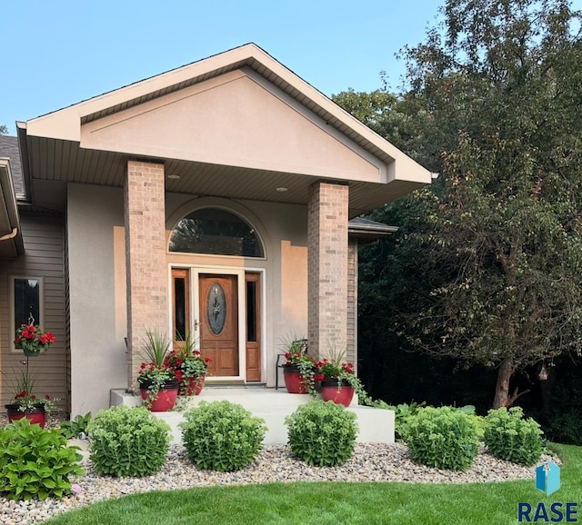 7 N Sun Valley Pl, Sioux Falls, SD 57110 - doorway to property with covered porch, stucco siding, and brick siding