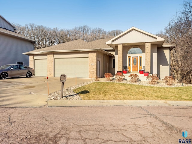 7 N Sun Valley Pl, Sioux Falls, SD 57110 - ranch-style house featuring brick siding, an attached garage, a shingled roof, and driveway
