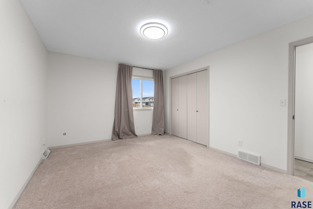 unfurnished bedroom featuring a closet, baseboards, carpet, and visible vents