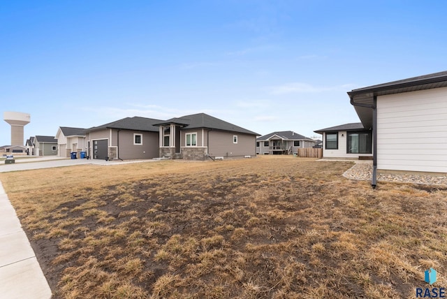 view of yard featuring driveway, a garage, and a residential view