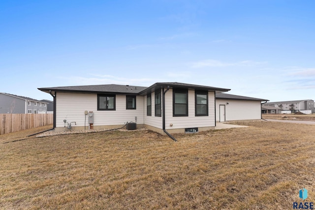 view of front of house featuring central air condition unit, fence, and a front lawn