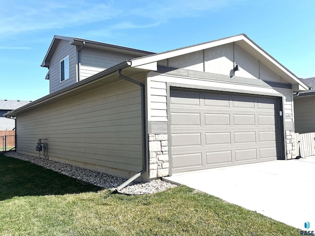 garage featuring driveway and fence