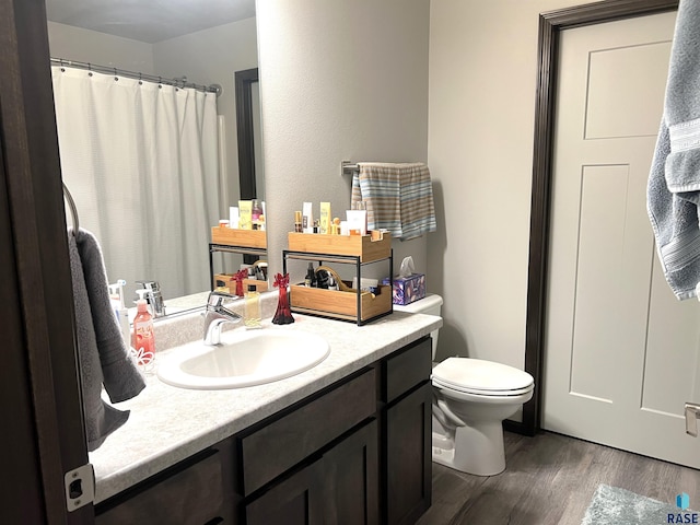 bathroom with curtained shower, vanity, toilet, and wood finished floors