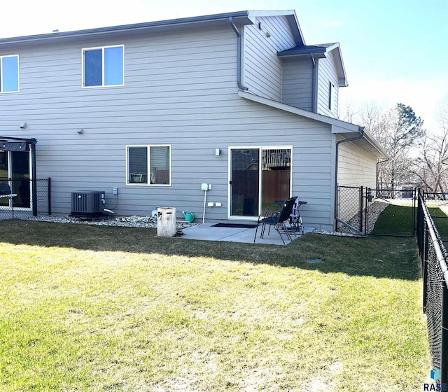 back of house with central AC, a fenced backyard, a yard, and a patio area