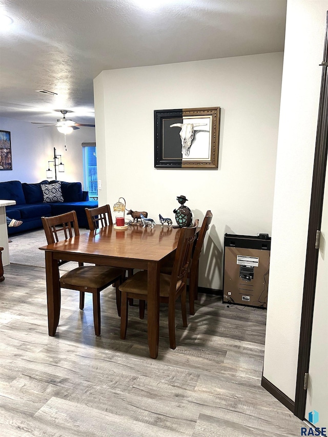 dining area with baseboards, a ceiling fan, and wood finished floors