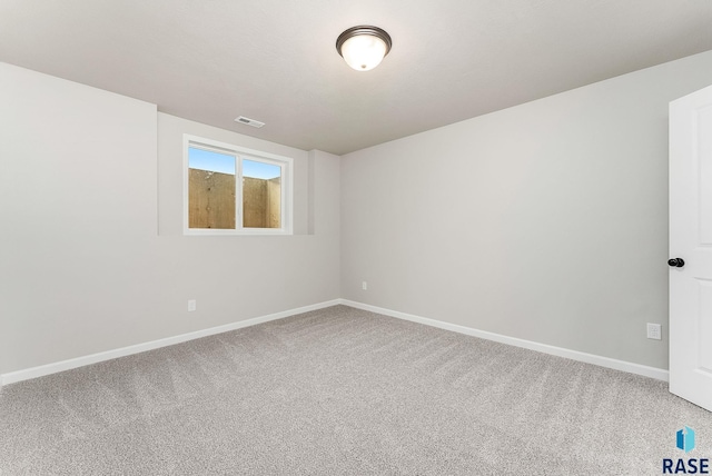 empty room featuring carpet flooring, visible vents, and baseboards