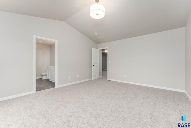 unfurnished bedroom featuring baseboards, lofted ceiling, and carpet floors