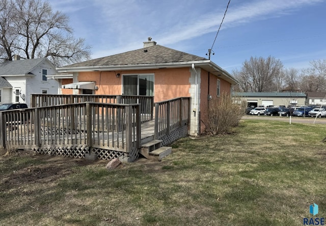 1413 E Rice St, Sioux Falls, SD 57103 - back of property featuring roof with shingles, a chimney, a wooden deck, and a lawn