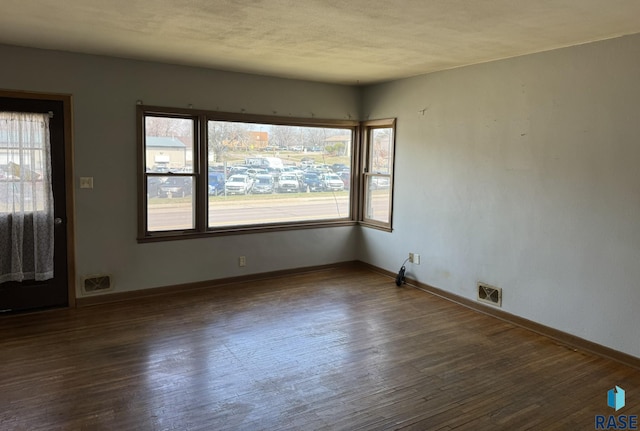 1413 E Rice St, Sioux Falls, SD 57103 - empty room with wood finished floors, baseboards, and visible vents