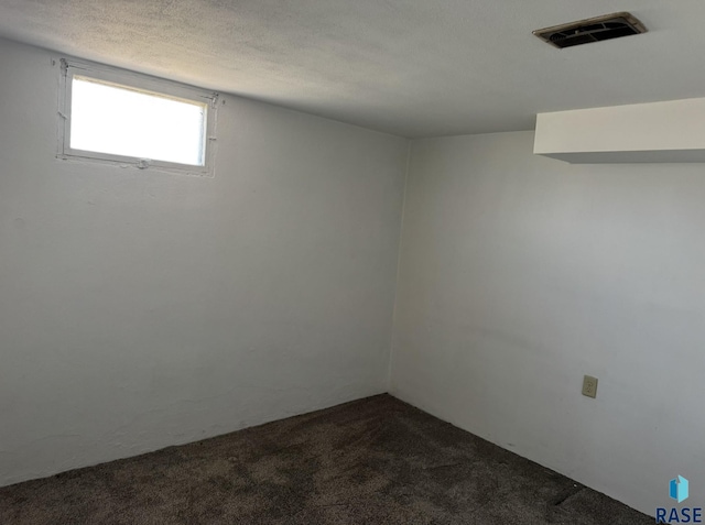 1413 E Rice St, Sioux Falls, SD 57103 - basement featuring a textured ceiling, dark colored carpet, and visible vents