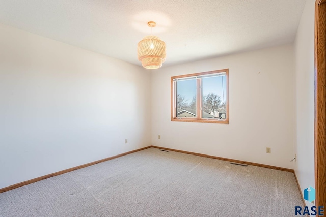 unfurnished room featuring visible vents, baseboards, and carpet