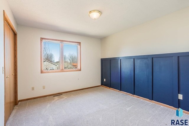 unfurnished bedroom featuring carpet floors, baseboards, and visible vents