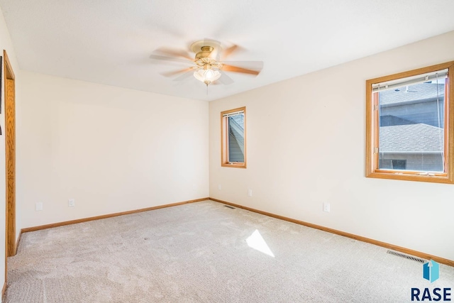 unfurnished room featuring light carpet, ceiling fan, baseboards, and visible vents