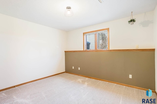 unfurnished room with baseboards and carpet