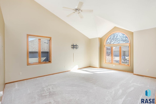 carpeted empty room with high vaulted ceiling, ceiling fan, and baseboards