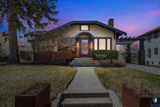 bungalow with a chimney, a pergola, entry steps, and a lawn