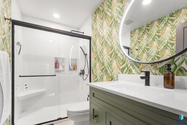 bathroom with toilet, vanity, wallpapered walls, and a stall shower